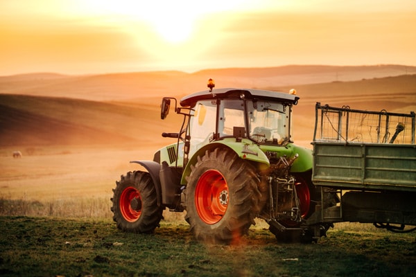 A tractor working the fields at sunset