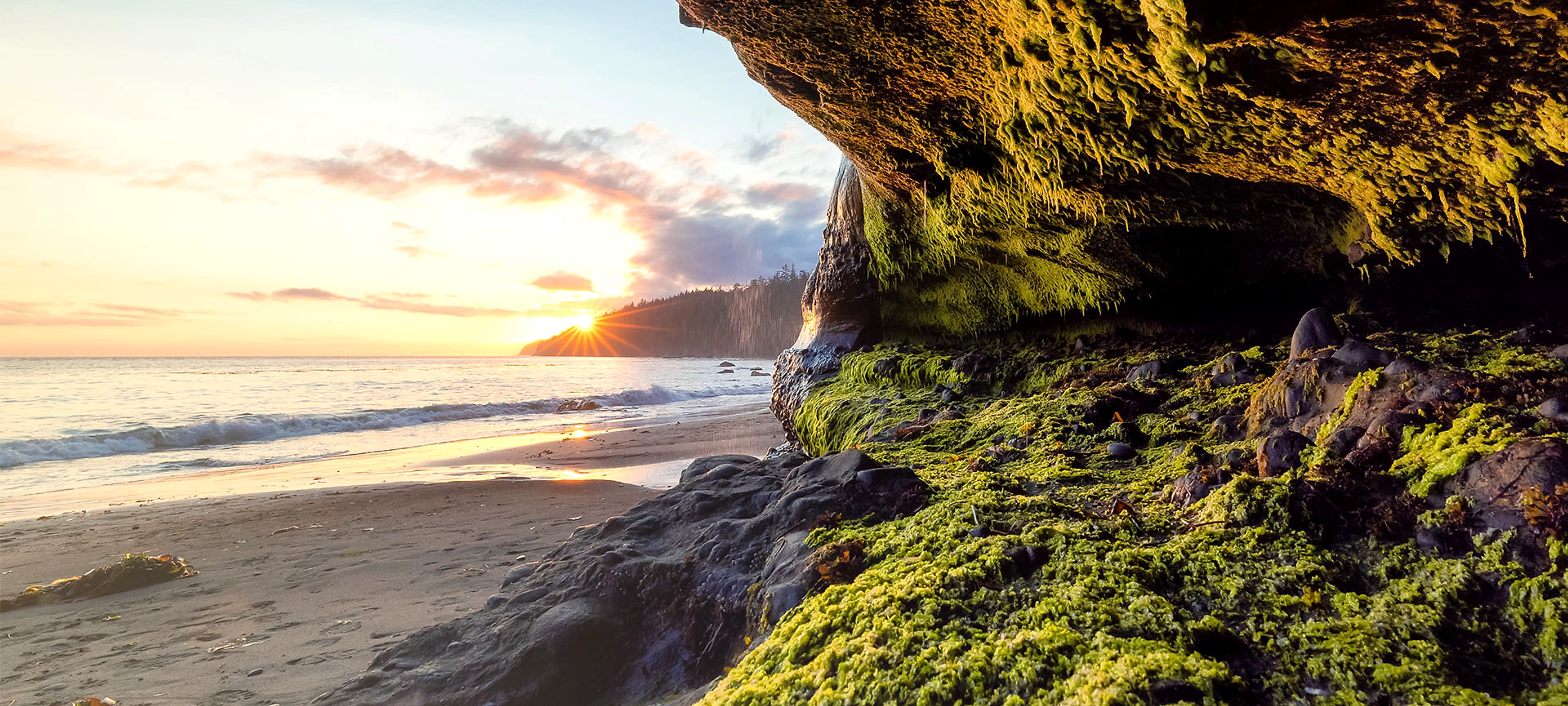 Sunrise breaking over a calm coastline