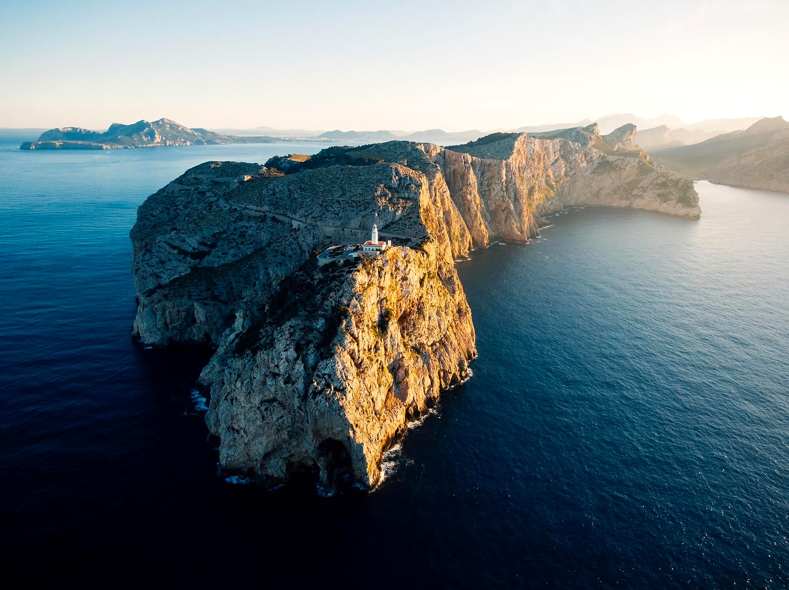 A lighthouse standing on a rocky cliff over the ocean